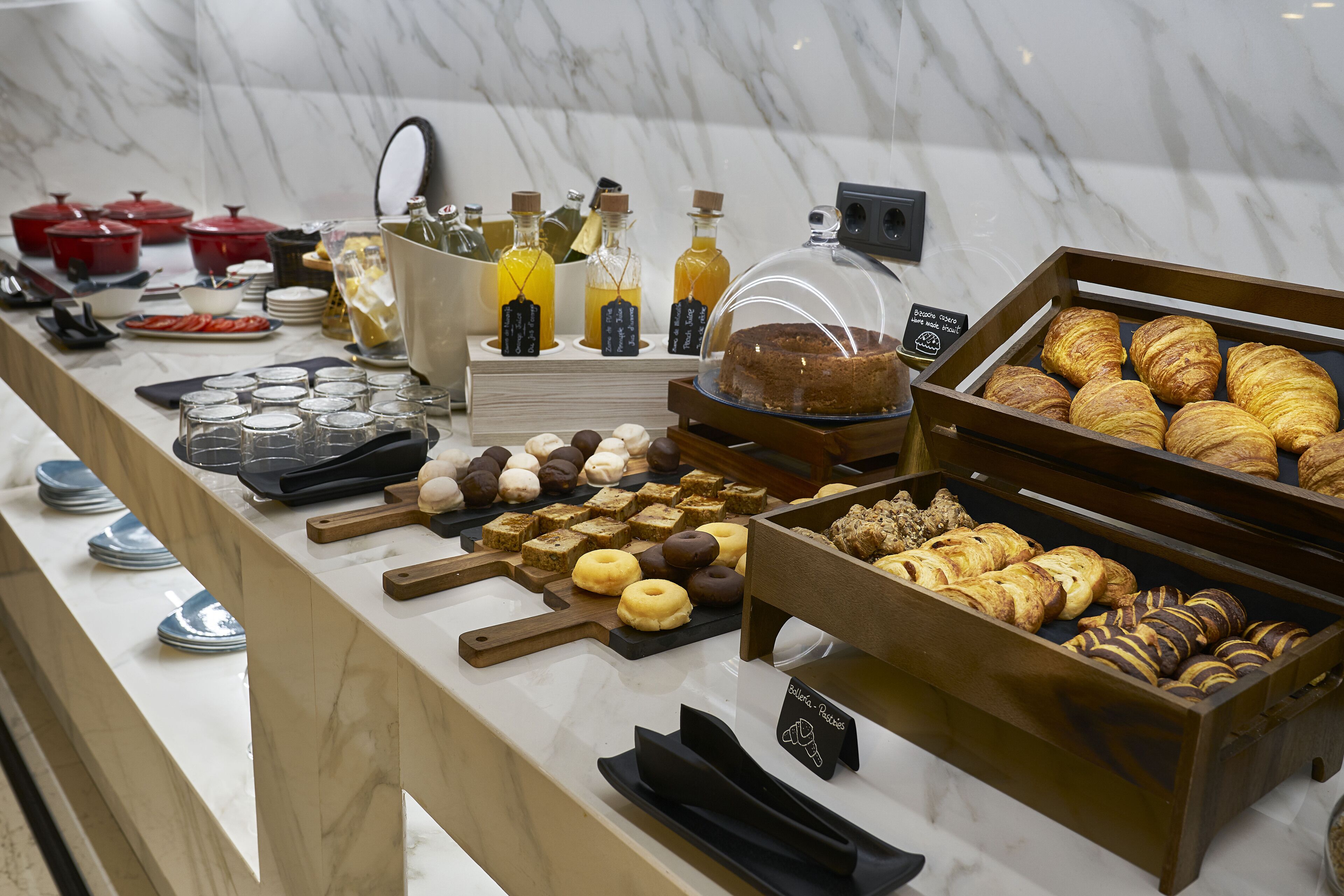 Een buffet met diverse gebakjes, een taart en toevoegingen.