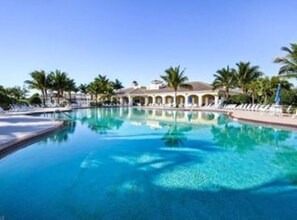 A large, clear swimming pool with a building in the background. - Beautiful home in private community close to the beach (Bonita Springs)