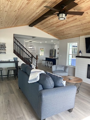 Relax in a spacious living area with a large sofa, coffee table, and mounted TV.