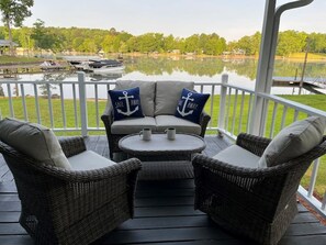 Guests can enjoy a serene lakeside seating area with a wicker sofa and armchairs.