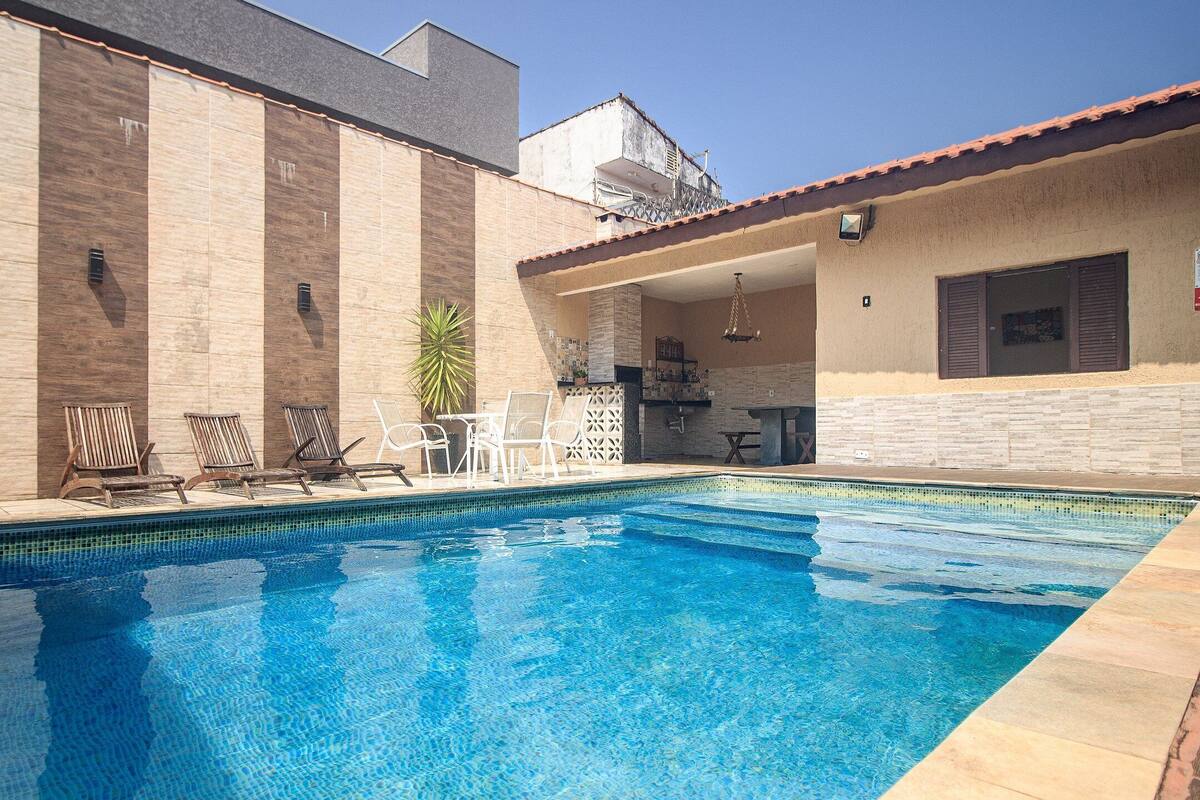 Una piscina con sillas de descanso y un área de terraza.