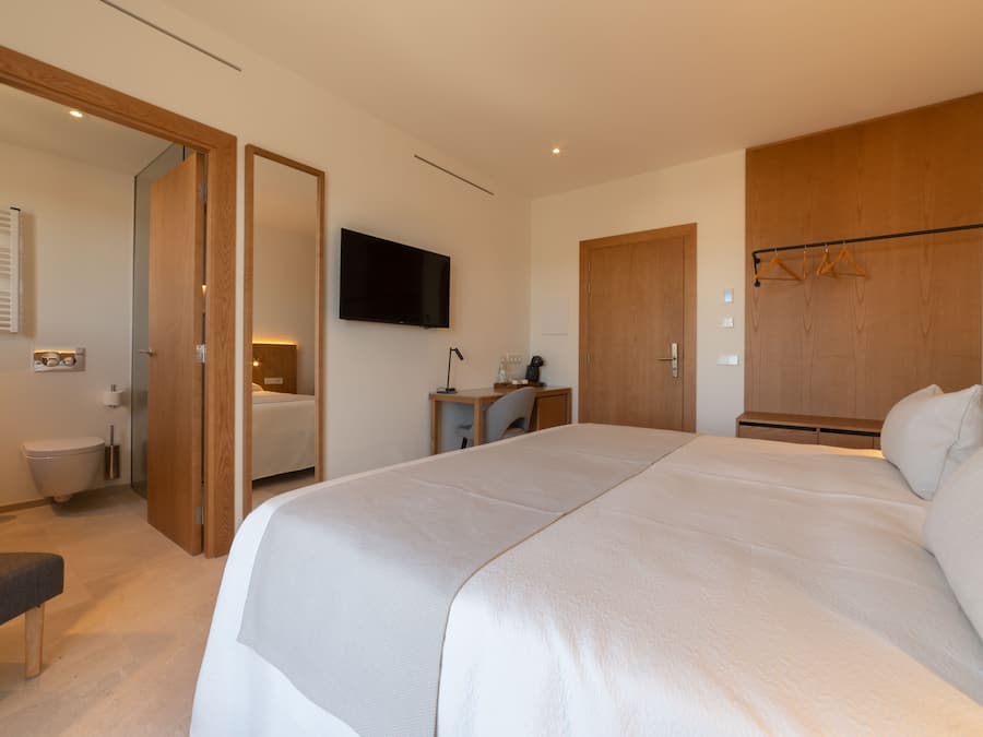 Une chambre à coucher avec un grand lit, un bureau avec une chaise, une télévision et une armoire.