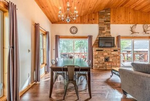 Enjoy meals in the dining area with a large table and chairs, and relax in front of the stone fireplace.