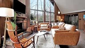 Una sala de estar acogedora con chimenea, ventanas amplias y asientos cómodos.