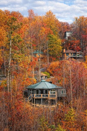 A cabin surrounded by autumn foliage, with a steep staircase leading to the entrance. - Fall Colors! BIG Views! Hot Tub, Modern, 10 min to Downtown! (Gatlinburg)