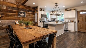 Une cuisine rustique avec des murs en bois, une table à manger en bois et des appareils électroménagers modernes.