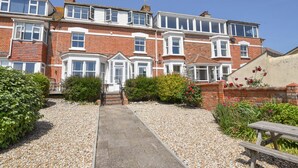 A row of terraced houses with a gravel pathway leading to the entrance.