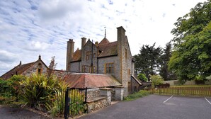 Un bâtiment en pierre, de style architectural traditionnel, avec de nombreuses cheminées et une grande entrée.