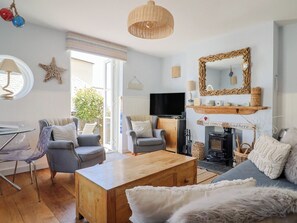 Una sala de estar con televisión, chimenea y zona de estar.