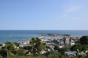 Eine Küstenstadt mit einem Jachthafen, Strand und Wohnhäusern.