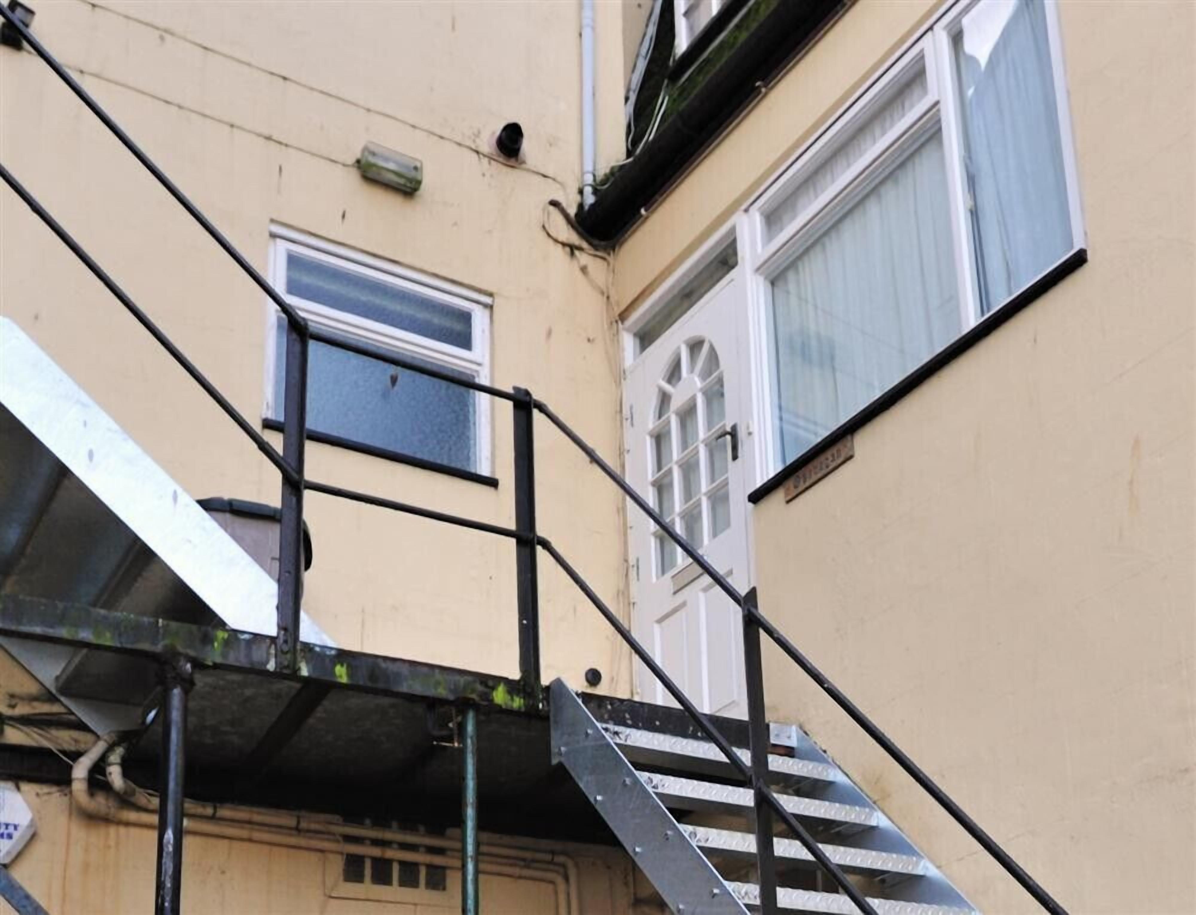 Una escalera metálica que conduce a la entrada de un edificio.