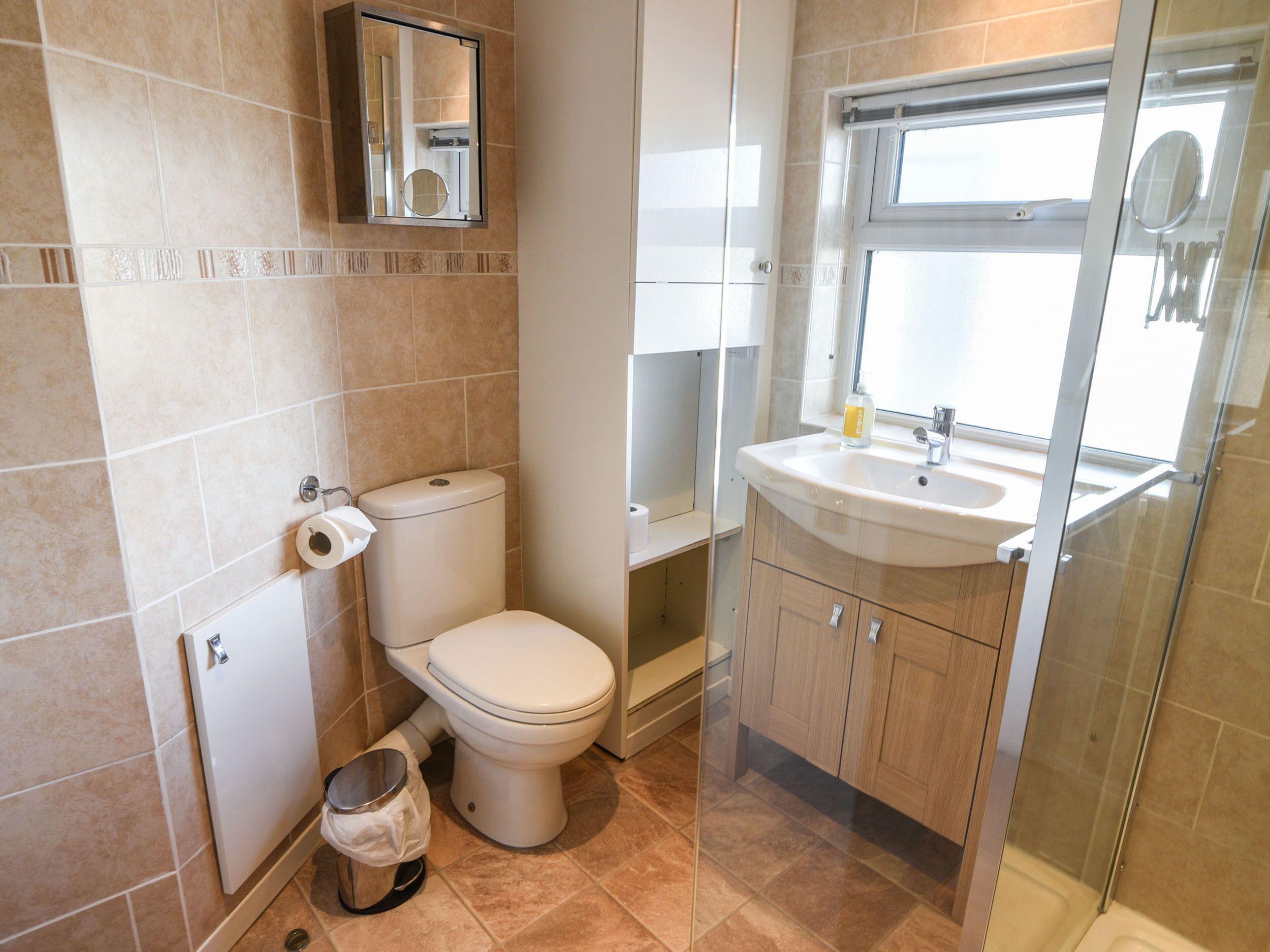 A bathroom with a toilet, a sink, and a mirror.