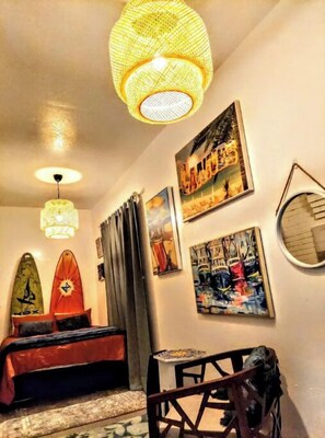 Een kamer met een bed, een tafel en kunstwerken aan de wanden.