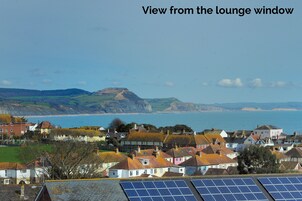 Vista costera con casas y paneles solares.