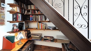 A staircase with a wooden handrail and black metal balusters. - Bedrock (Lyme Regis)