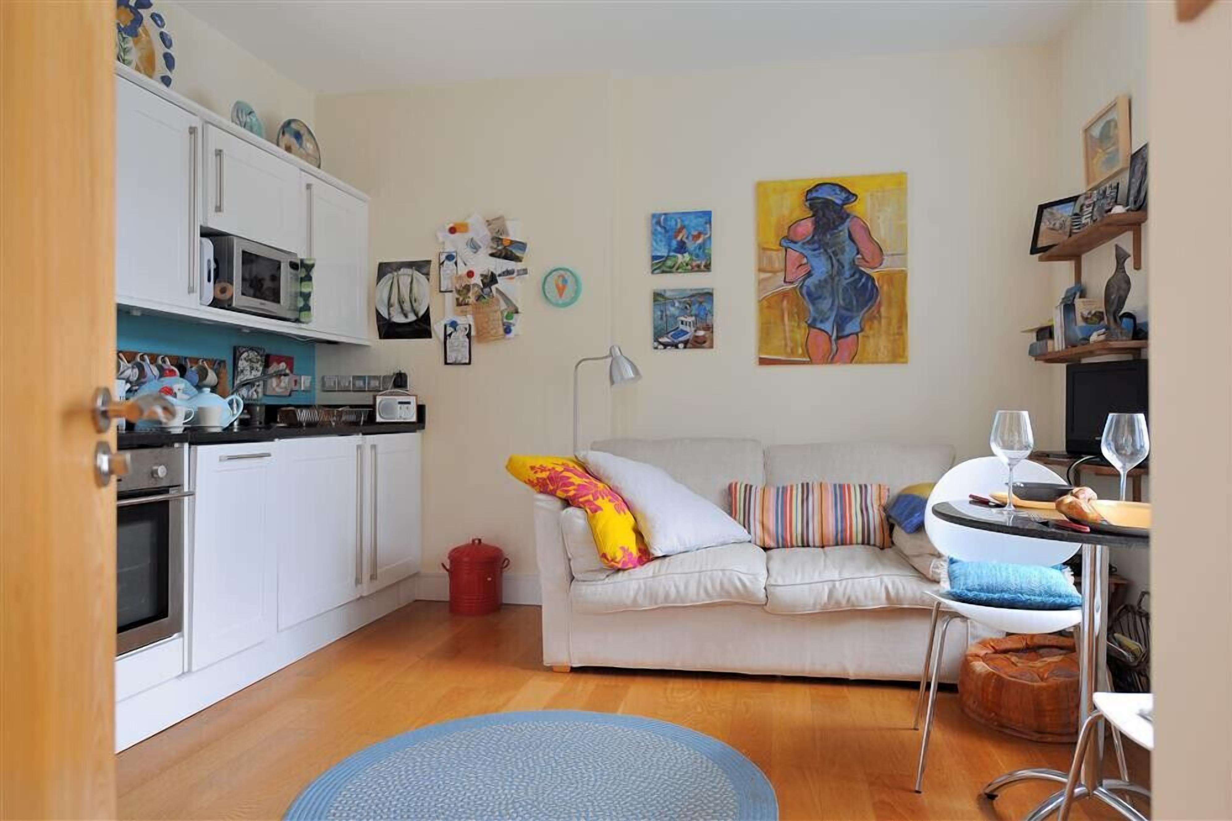 A compact living space with a kitchenette, a sofa, and a dining area.