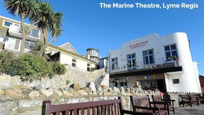 The Marine Theatre, a white building with a balcony and a sign reading "MARINE THEATRE". - 4 Bay View Court (Lyme Regis)