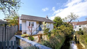 Une maison avec un jardin et un canal.