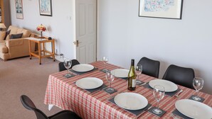 Un coin repas avec une nappe à carreaux, des assiettes blanches et des verres à vin, le tout préparé pour un repas.