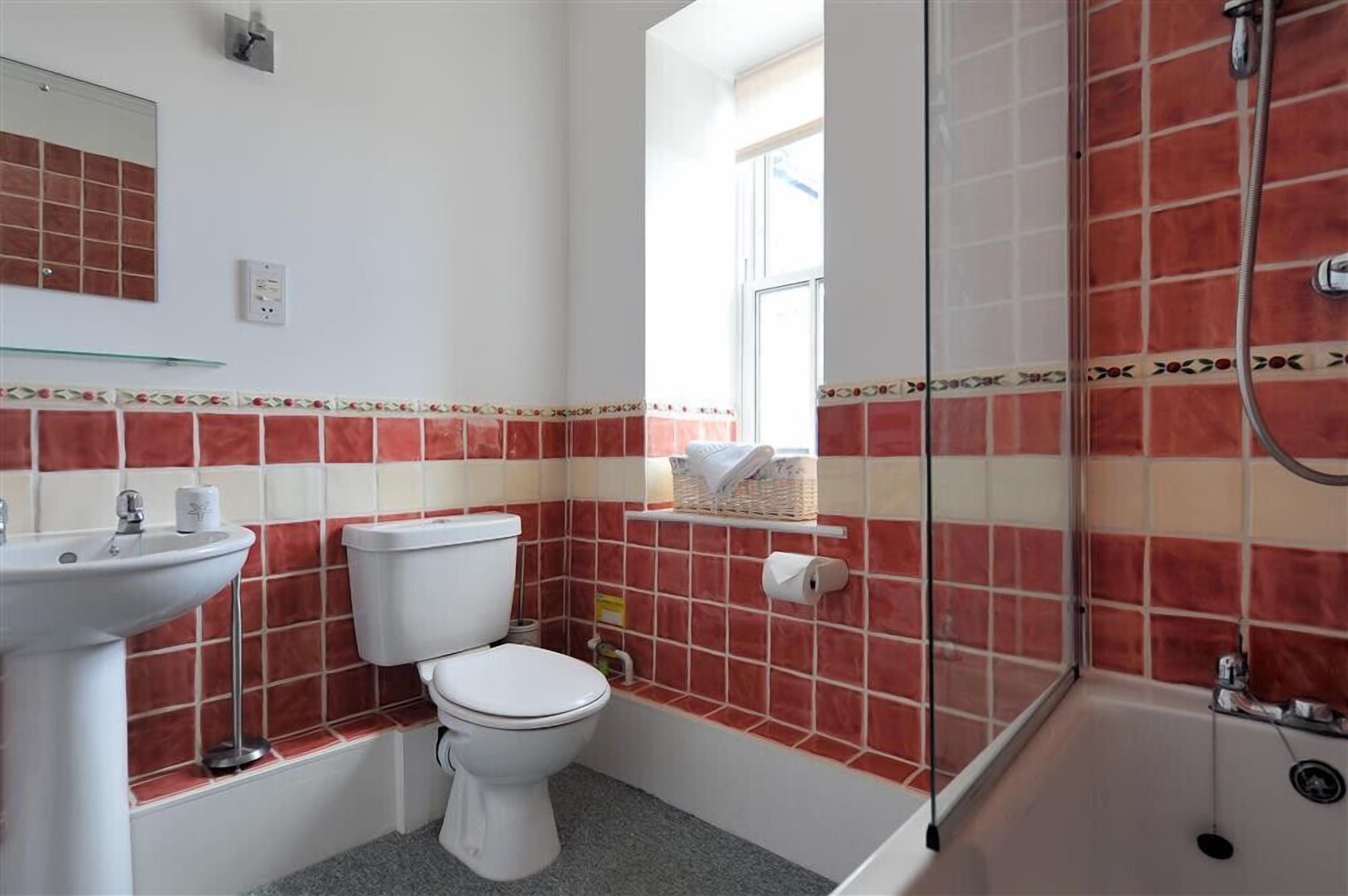 A bathroom with a toilet, sink, and shower.