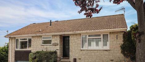 A two-story house with a tiled roof, a front door, and a garage.