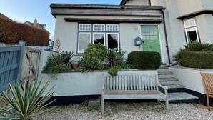 A house with a green door, a mailbox, and a bench in the front yard. - The Apartment at Queen Anne's Lodge (Lyme Regis)