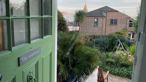 A green door with a sign reading "The Apartment." - The Apartment at Queen Anne's Lodge (Lyme Regis)