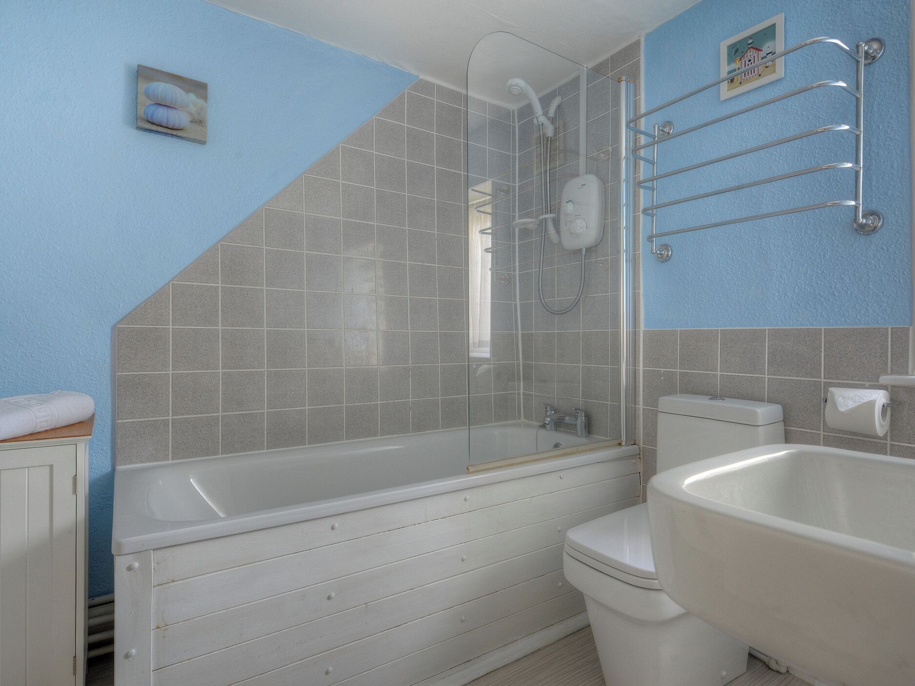 A bathroom with a bathtub, toilet, and shower area.