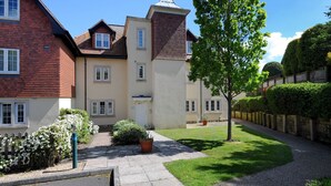 A residential building with a brick facade, multiple windows, and a well-maintained lawn. - 8 Buckfields (Lyme Regis)