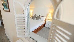 Ett sovrum med en säng, två sänglampor och en inramad tavla på väggen.