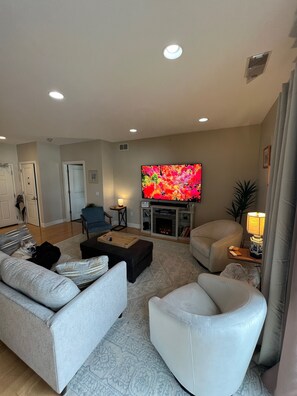 Un salón amplio con chimenea, un televisor de pantalla plana y una zona de estar acogedora.