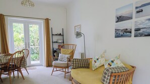 A cozy living room with a sofa, chairs, a small table, and a bookshelf.
