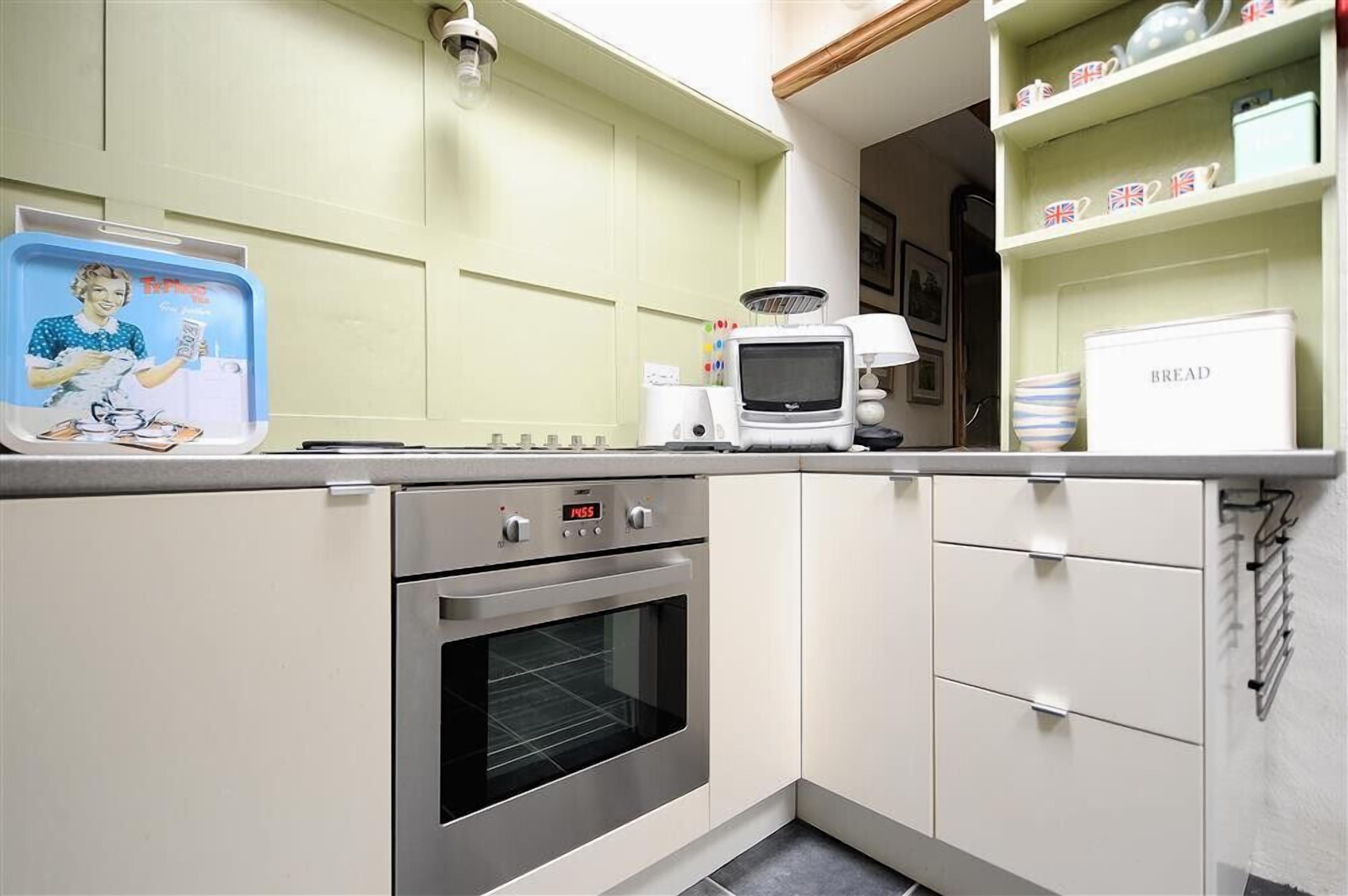 Una cocina con microondas, horno y cafetera en la encimera.
