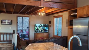 Una cucina con un'isola grande, travi in legno e un frigorifero in acciaio inossidabile.