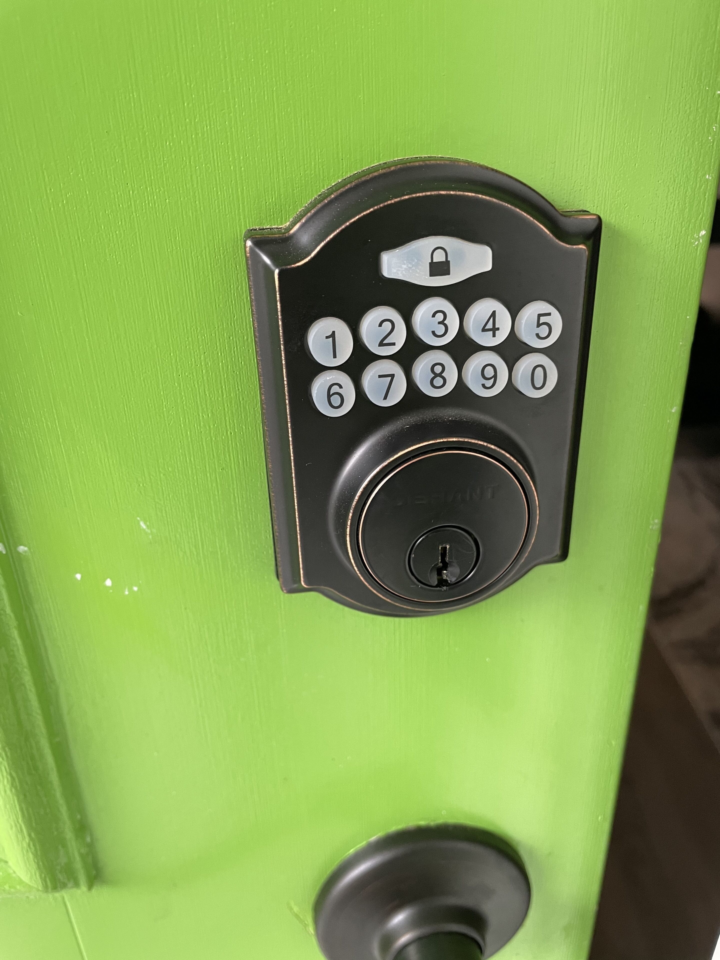 A green door with a numeric keypad lock.