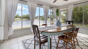 Un espace repas comprenant une table, des chaises et un ventilateur de plafond.