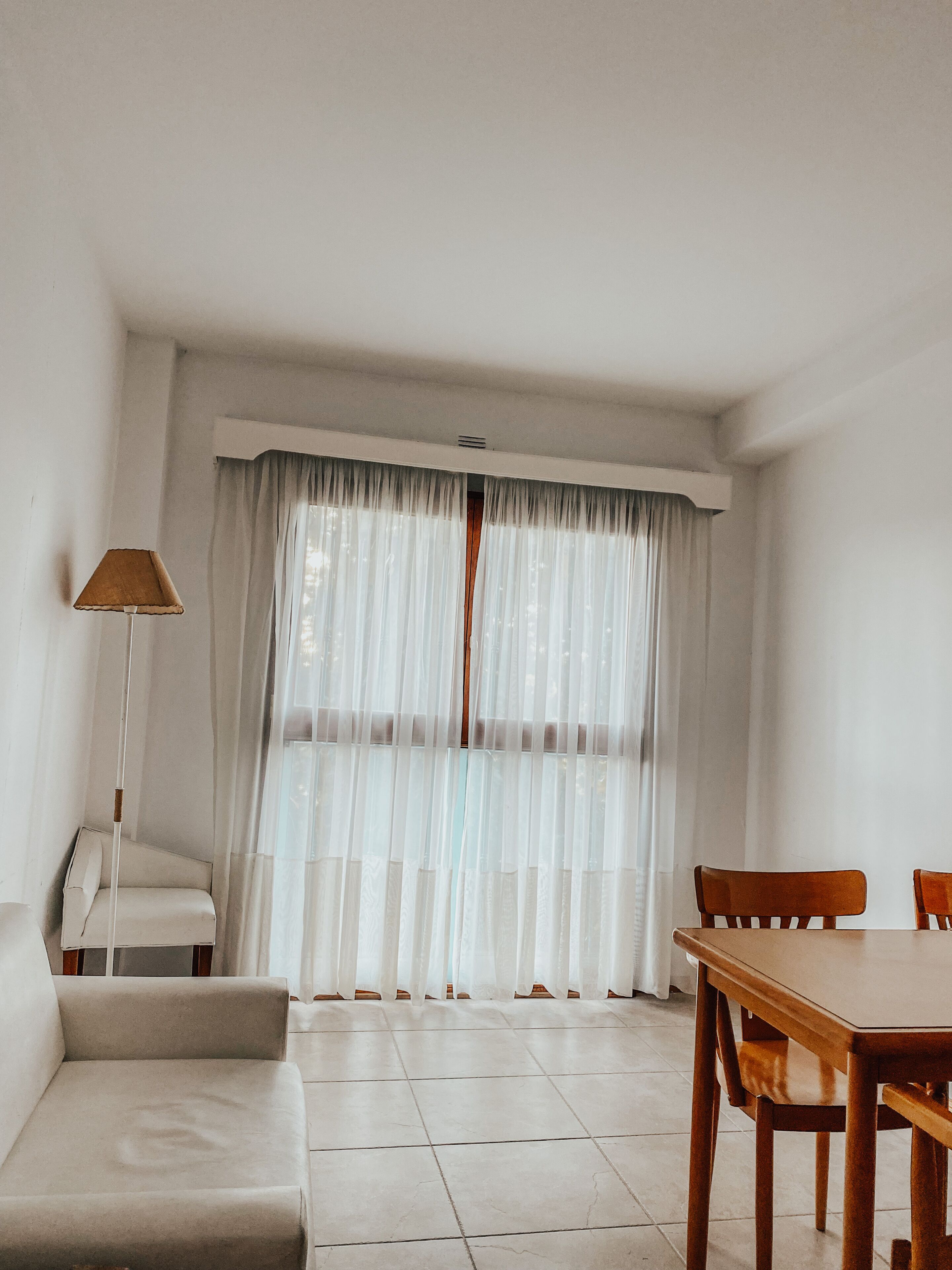A minimalist living room with a sofa, a dining table, and chairs.