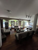 Uma sala de estar ampla com sofá, mesa de centro e televisão.