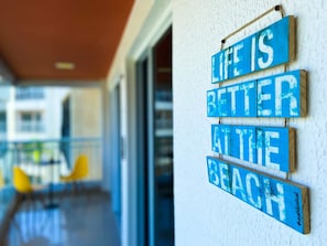 A blue sign with white lettering on a wall, reading 'Life is better at the beach.' - Solarium Residence Resort (Aquiraz)