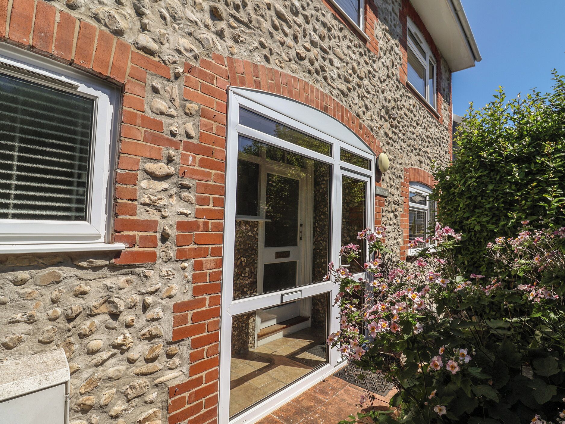 A stone building with a brick facade, a large window, and a door.