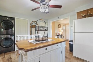 Kitchen with central island, stainless steel appliances, and white cabinetry.