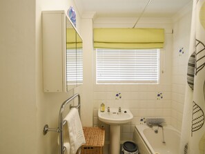 A bathroom with a sink, mirror, and window with blinds. - Byeways (Axminster)