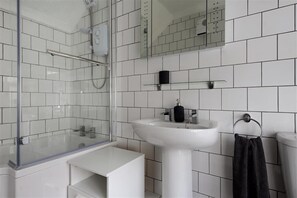 A modern bathroom with a glass-enclosed shower, a white sink, and a toilet. - Hatchett Top Flat (Lyme Regis)