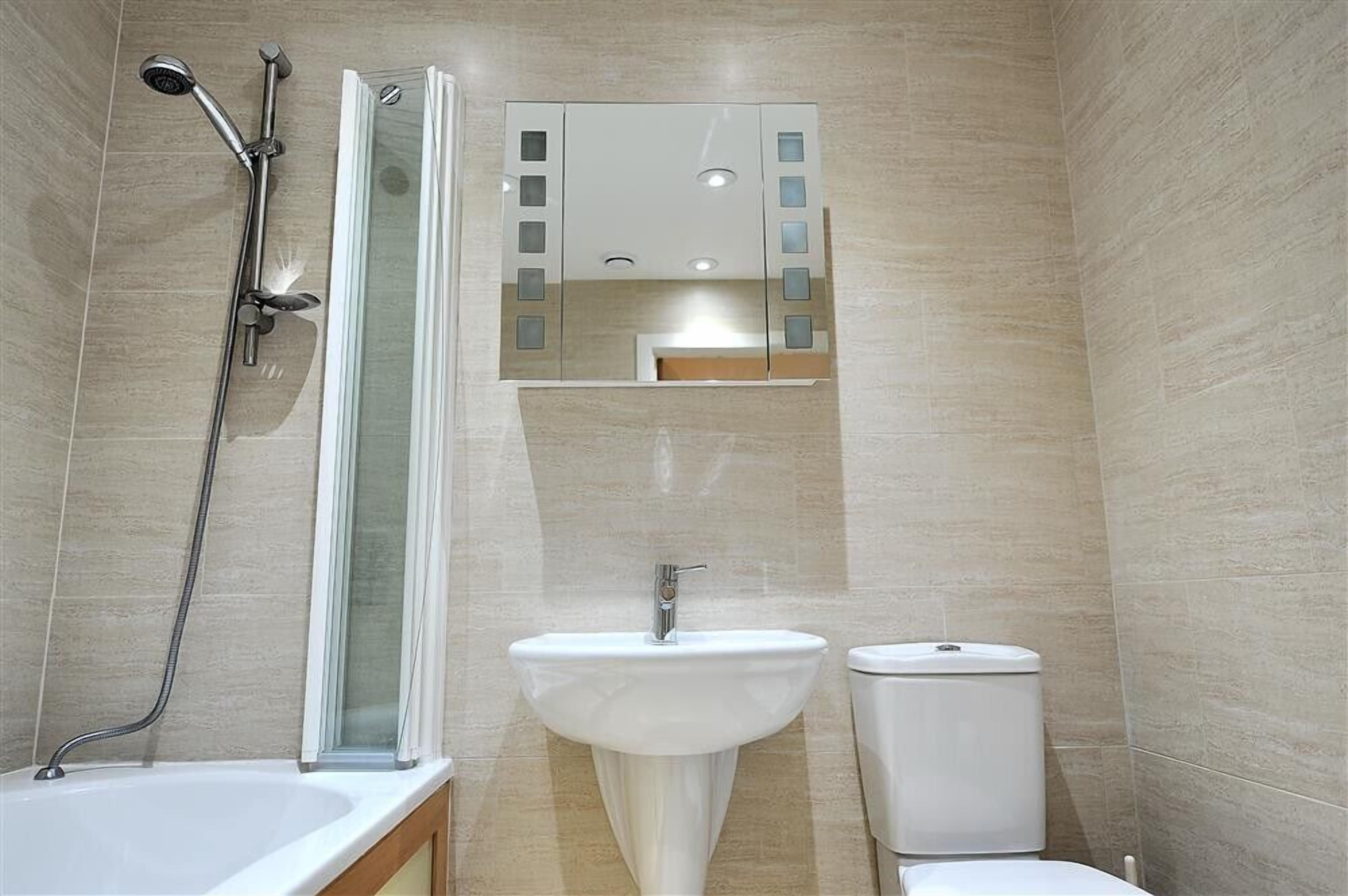 A bathroom with a bathtub, a sink, a toilet, and a shower with a glass door.