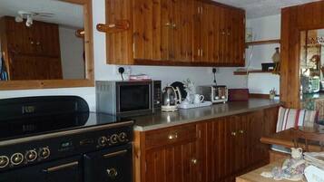 A kitchen with wooden cabinets, a microwave, a toaster, and a stove.