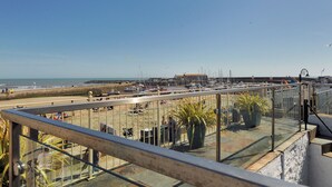 A coastal view with a marina, beach, and a building in the background. - Captains House (Lyme Regis)