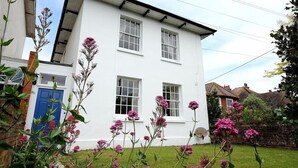 A white two-story house with a blue door and windows. - The White House (Bridport)
