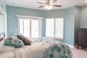 A bedroom with a bed, a ceiling fan, and a dresser.