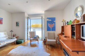 A modern living room with a sofa, chairs, a TV, and a wooden cabinet. - Lyme Time (Lyme Regis)