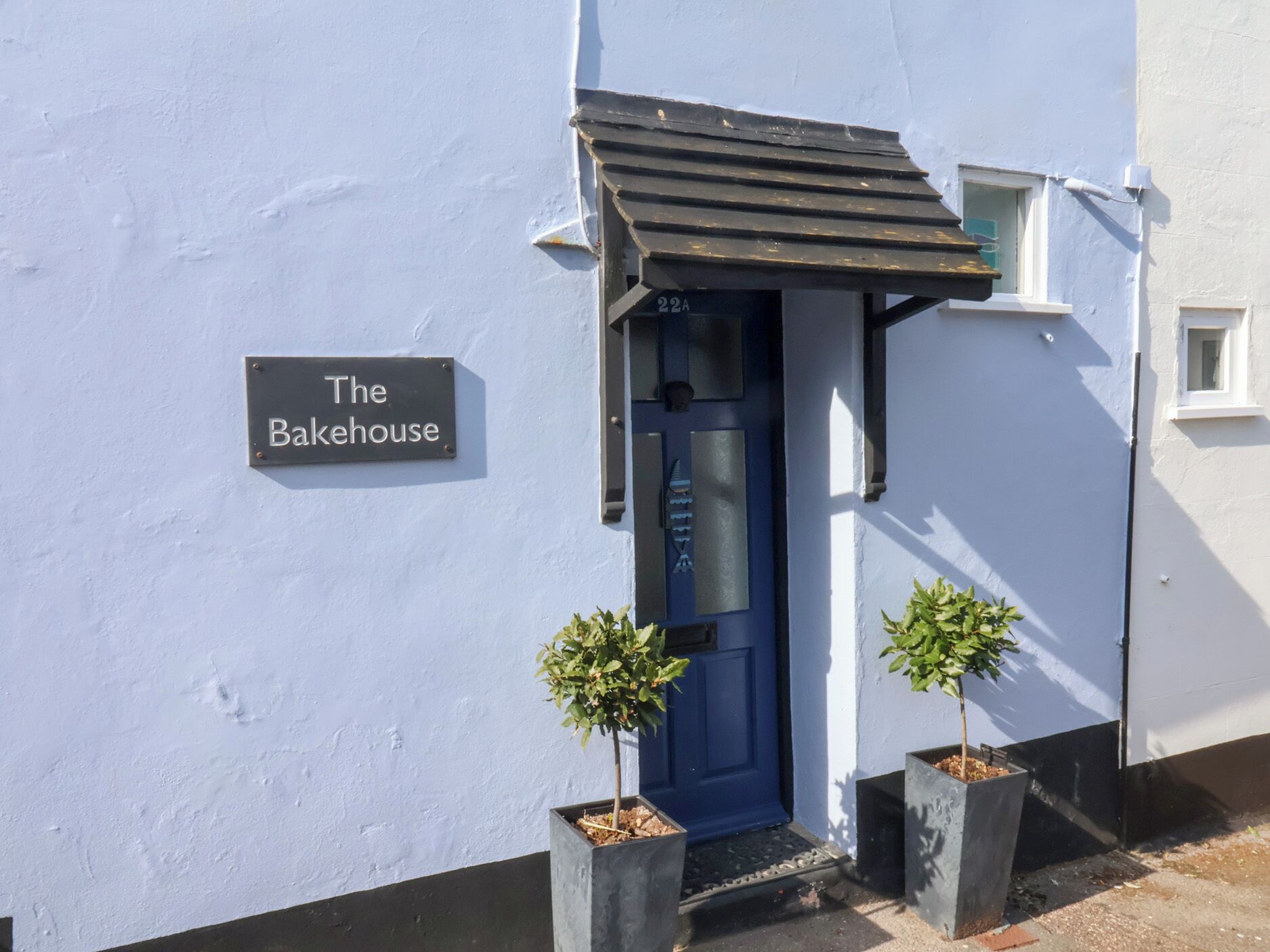 Un edificio con un cartello che riporta la scritta 'The Bakehouse' e una porta blu.